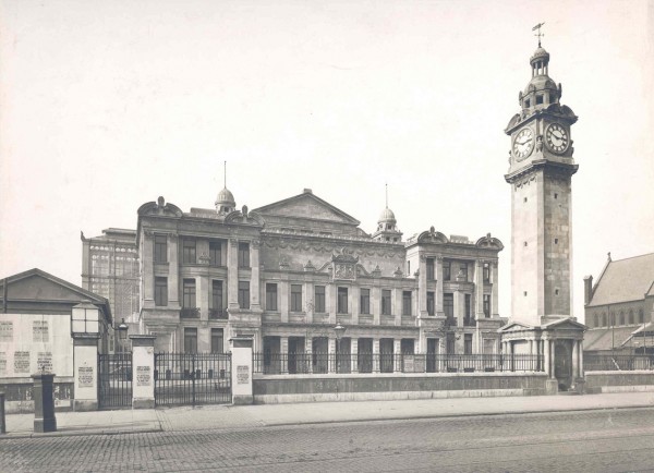 Black and white photograph of the Peoples Palace building from about 1890.  A clock tower can be seen in the foreground.  